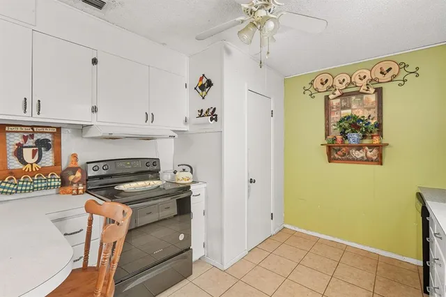 a kitchen with granite countertop a stove a sink and a refrigerator
