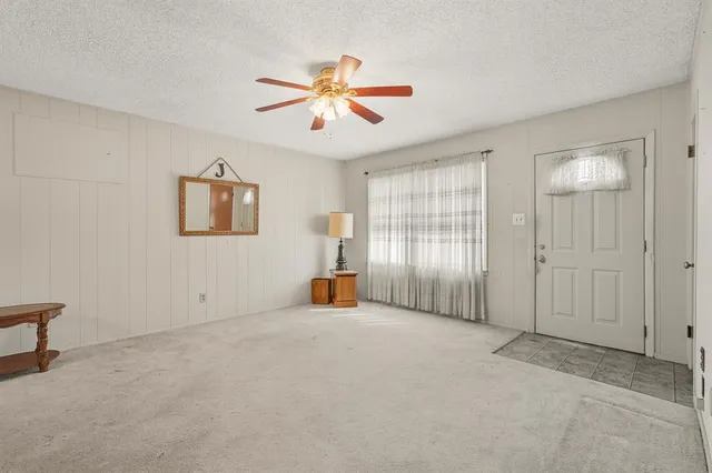 an empty room with fan and windows