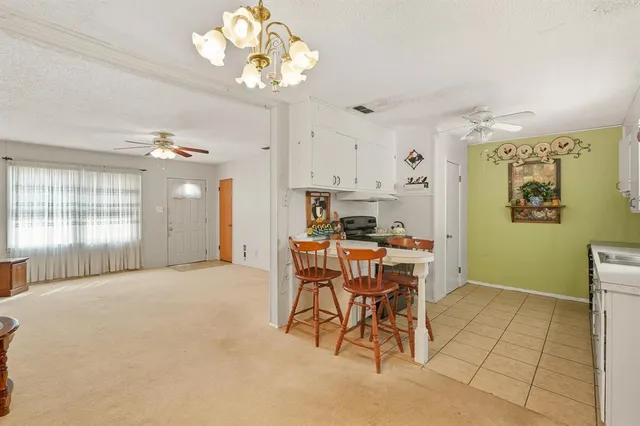 a view of a dining room with furniture and a chandelier