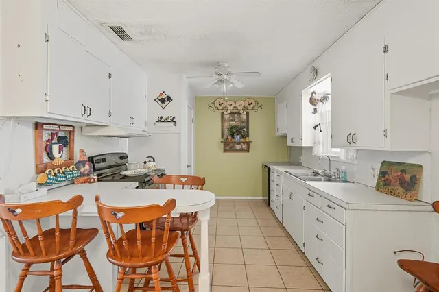 a kitchen with stainless steel appliances a stove a sink dishwasher and cabinets with wooden floor