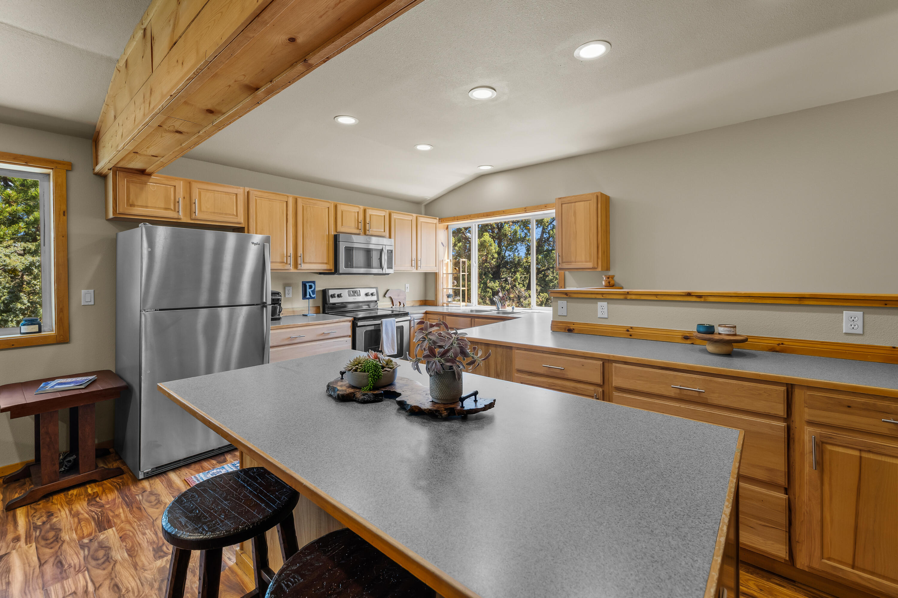 64145 Hunnell Road Bend, OR 97703 - Photo 51 of 65 The finished upper-level guest/flex quarters above the shop include a kitchen area with Whirlpool appliances, island seating and an open connection to the adjoining living space.