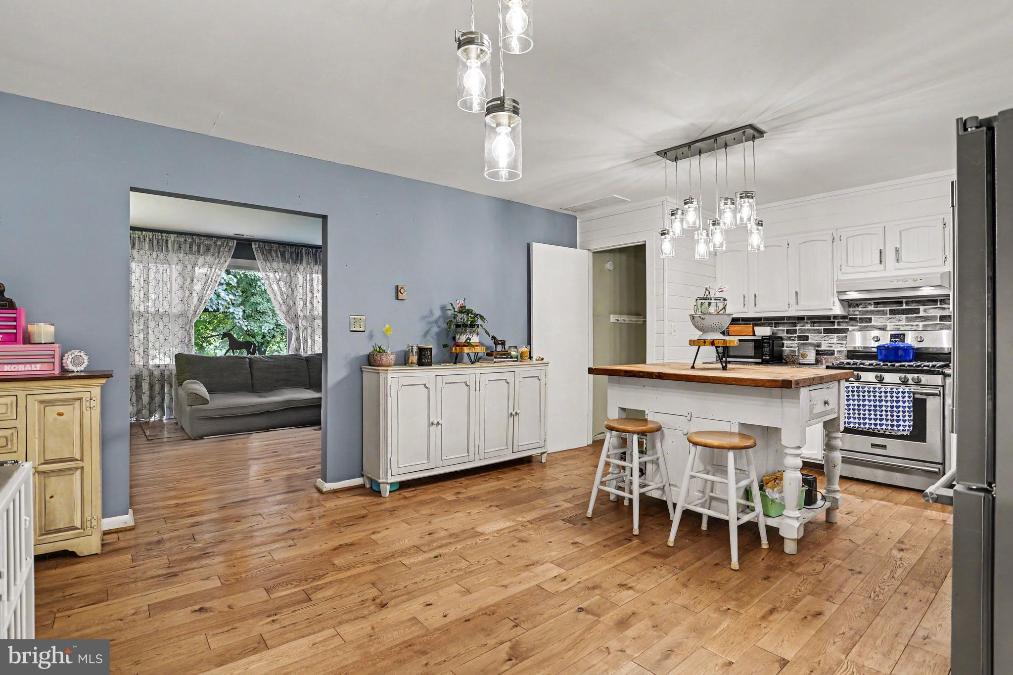 2226 Harney Road Littlestown, PA 17340 - Photo 10 of 40 a kitchen with stainless steel appliances a dining table chairs and wooden floor
