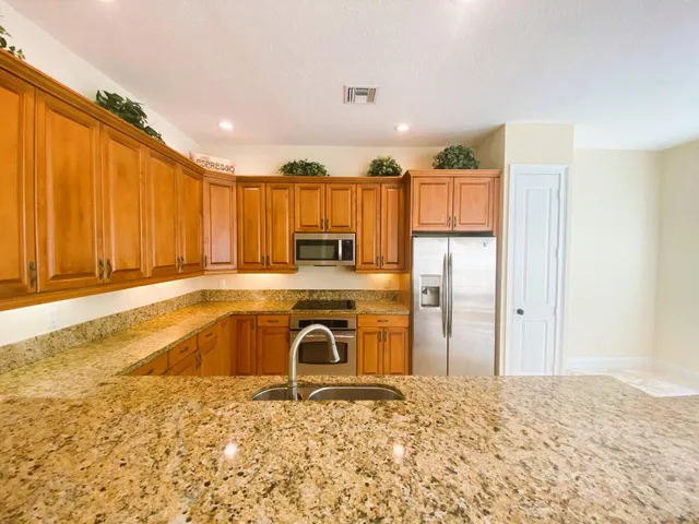 a view of a kitchen with a stove top oven and refrigerator