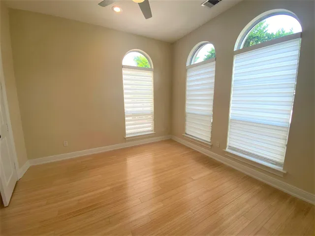 an empty room with a window and wooden floor