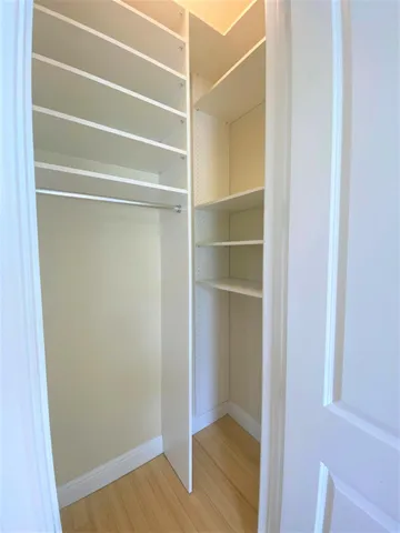 a view of walk in closet with empty racks