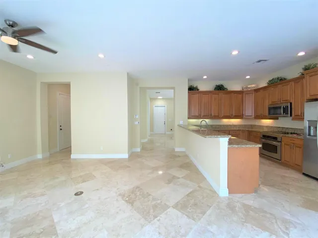 a large kitchen with stainless steel appliances kitchen island granite countertop a sink and cabinets