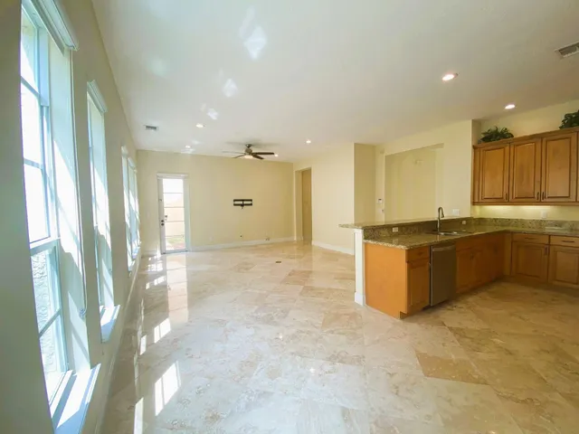 a view of a kitchen with kitchen island a sink wooden floor and counter top space