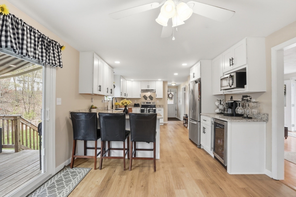 18 Trifiro Road Billerica, MA 01821 - Photo 19 of 42 a kitchen with stainless steel appliances granite countertop a refrigerator a stove top oven a sink dishwasher a dining table and chairs with wooden floor