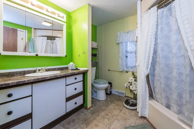a bathroom with a granite countertop sink a toilet and a bathtub