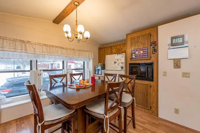 a view of a dining room with furniture a chandelier and wooden floor