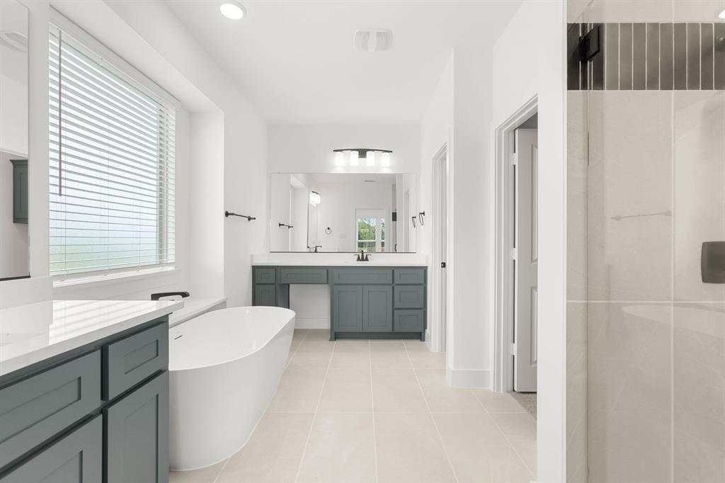 413 Tower Street DeSoto, TX 75115 - Photo 21 of 30 a bathroom with a double vanity sink a mirror and a bathtub