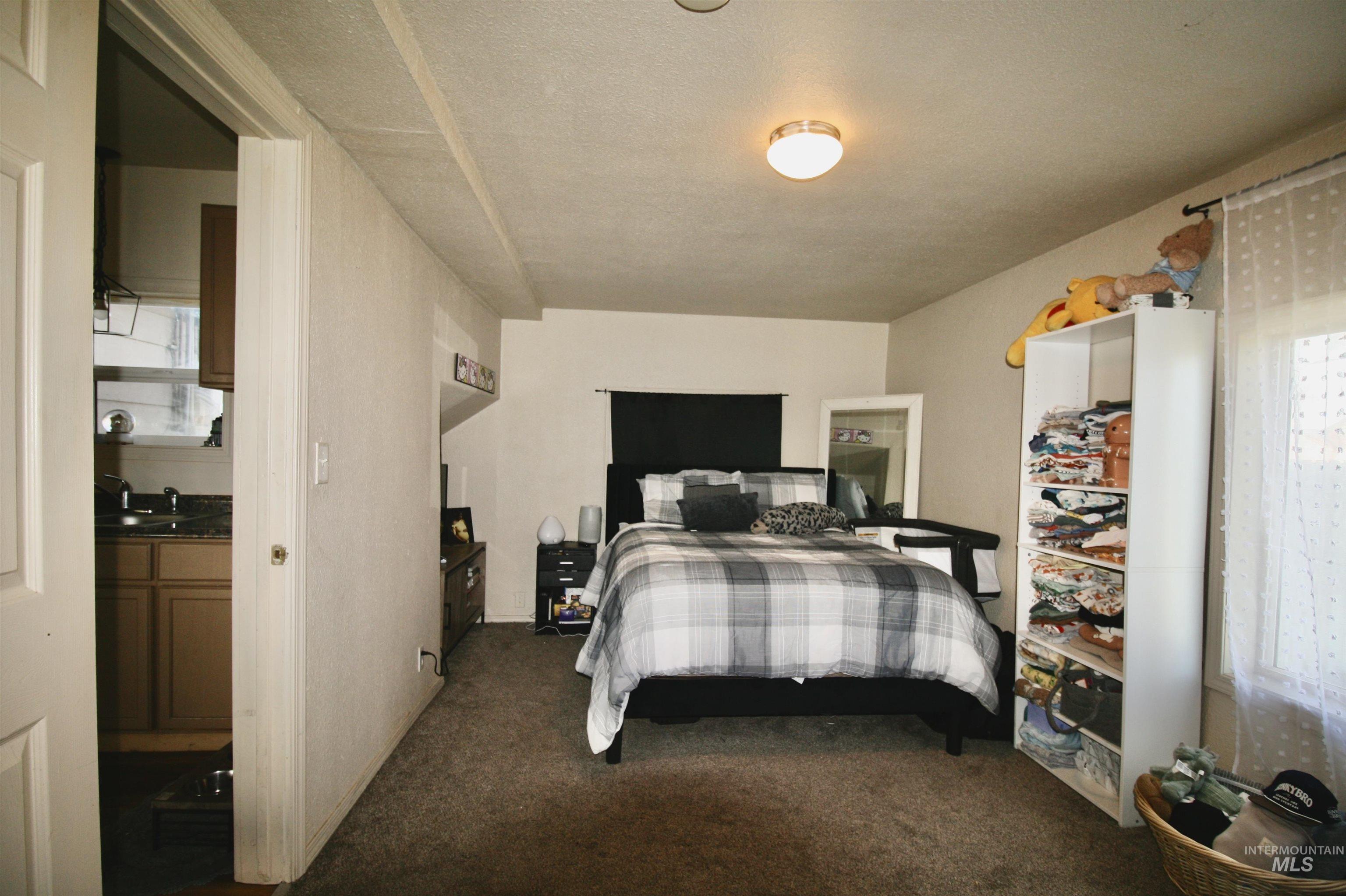 539 North 2nd Street Nyssa, OR 97913 - Photo 12 of 18 Bedroom featuring dark carpet and a textured ceiling