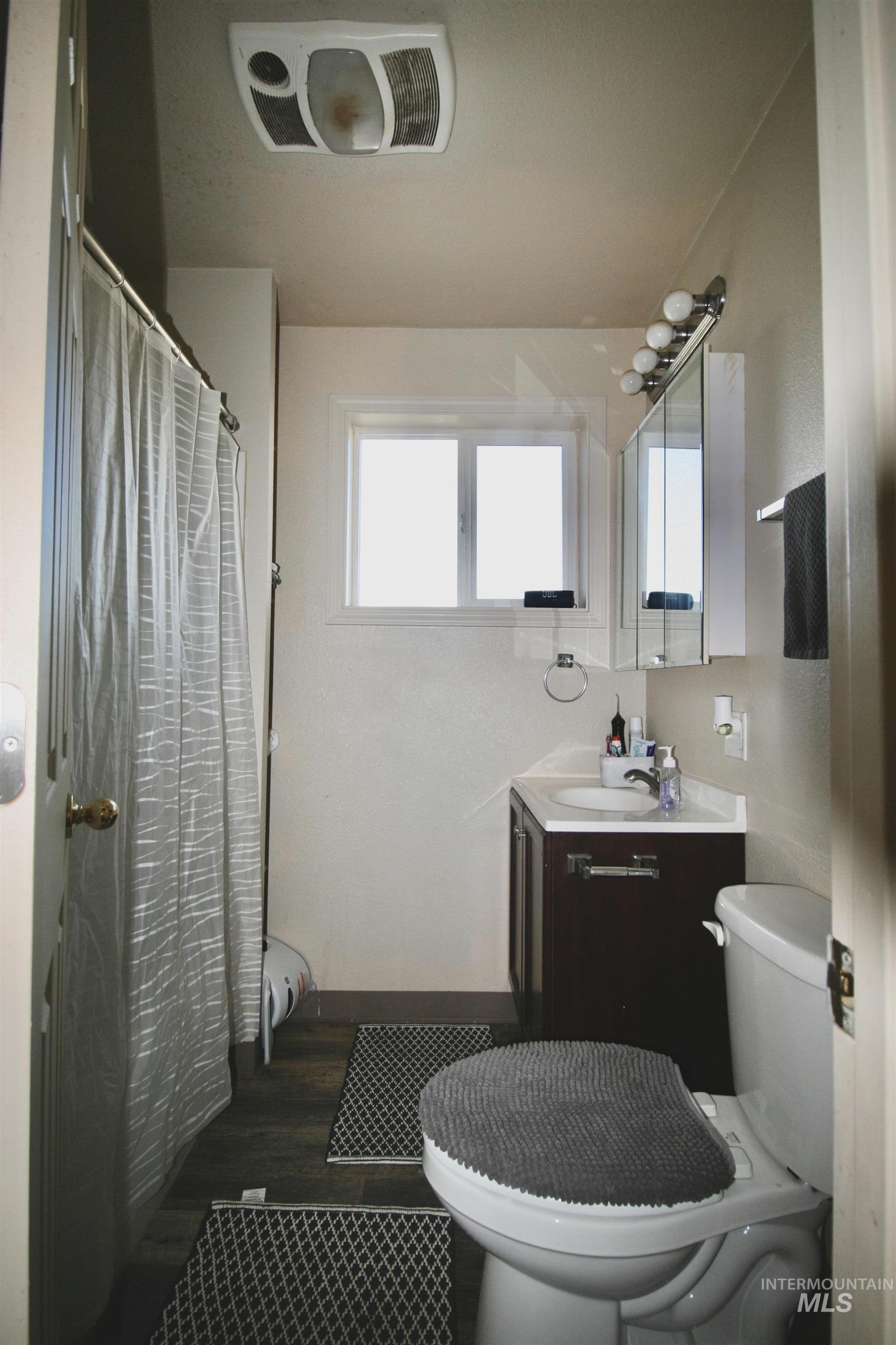 539 North 2nd Street Nyssa, OR 97913 - Photo 17 of 18 Full bath featuring curtained shower, vanity, and dark wood finished floors