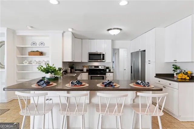 a view of a dining room with furniture a kitchen and chandelier