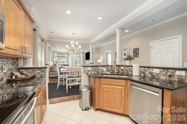 a kitchen with stainless steel appliances granite countertop a sink a stove and a refrigerator