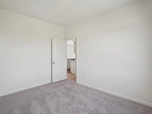 a large white kitchen with wooden floor and a refrigerator