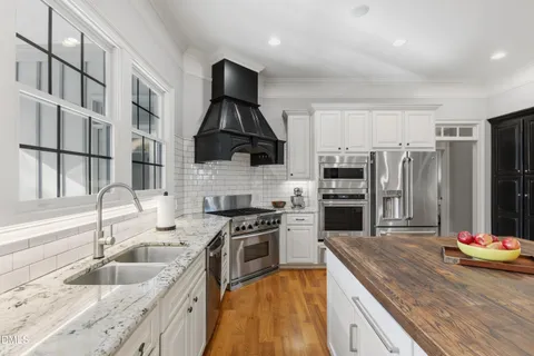 a kitchen with kitchen island granite countertop a sink stainless steel appliances and cabinets