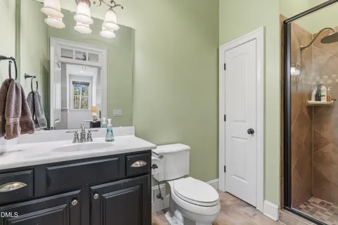 a bathroom with a granite countertop toilet sink and mirror