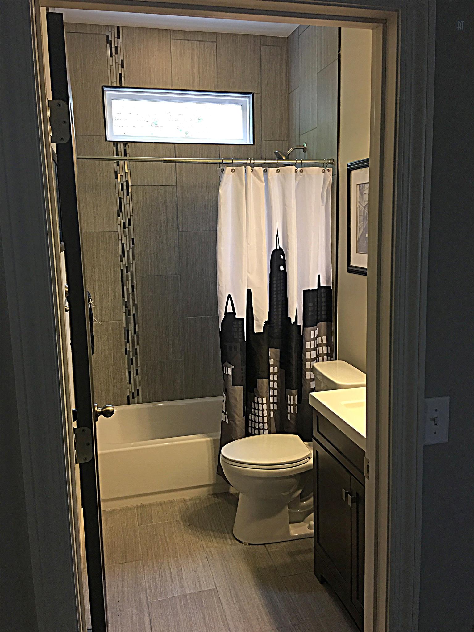 213 Warrior Road Madison, TN 37115 - Photo 8 of 11 High ceiling bath with dramatic tile to ceiling with accent, transom window, tile floor, nice vanity, faucet, mirror and light fixture. Stylish.