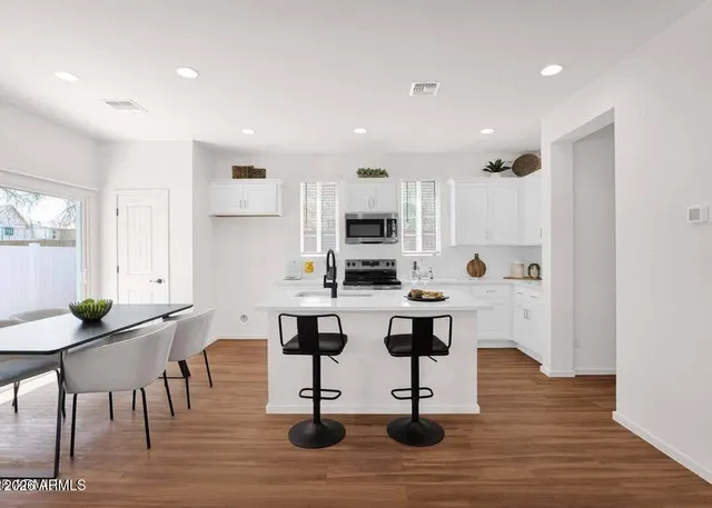 a view of kitchen with cabinets table and chairs