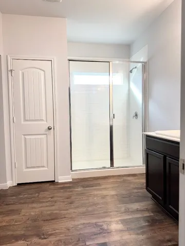 a view of a livingroom with wooden floor and a kitchen space