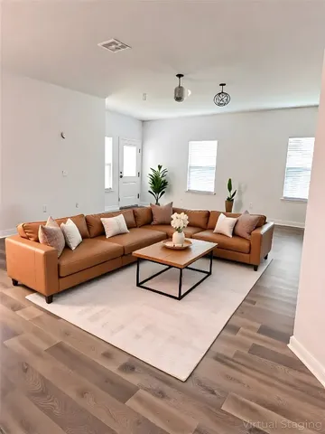 a living room with furniture and wooden floor