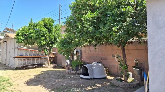 a backyard of house with wooden fence and trees