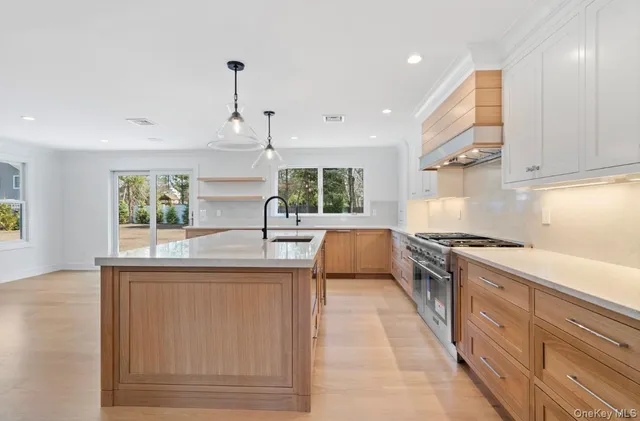 a kitchen with stainless steel appliances granite countertop a sink a stove and a wooden floors