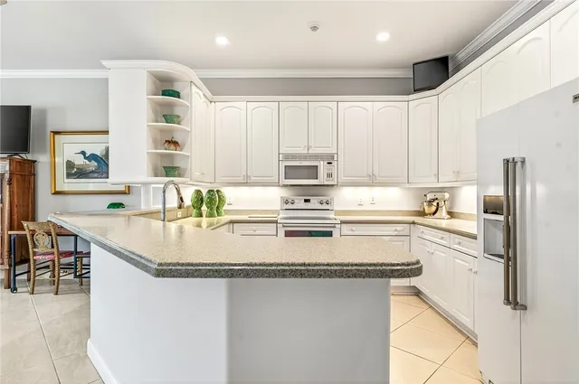 a kitchen with stainless steel appliances granite countertop a sink and a refrigerator