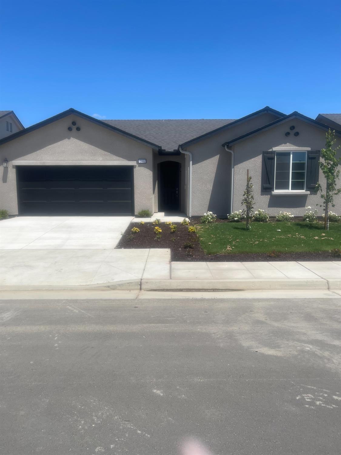 13332 4th Street, Unit LOT2 Parlier, CA 93648 - Photo 1 of 1 a front view of a house with a yard and garage