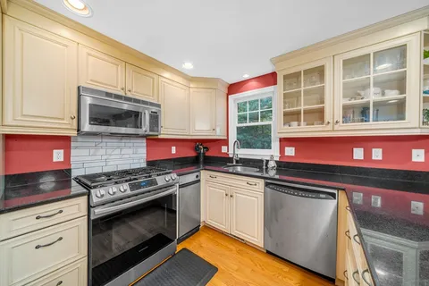 a kitchen with stainless steel appliances granite countertop a stove and a microwave