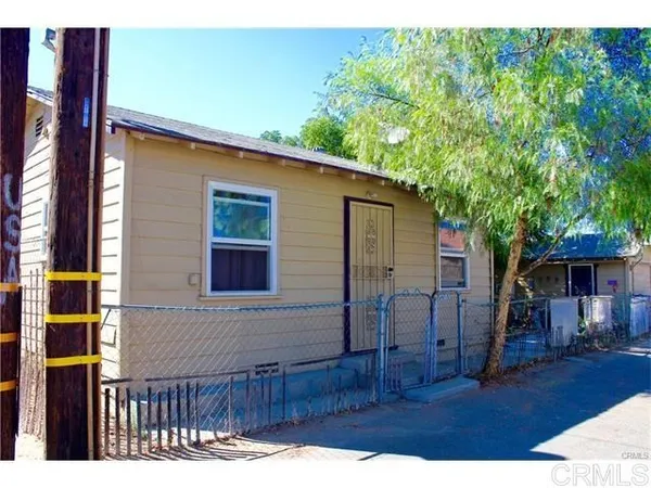 a view of backyard with barbeque grill and wooden fence