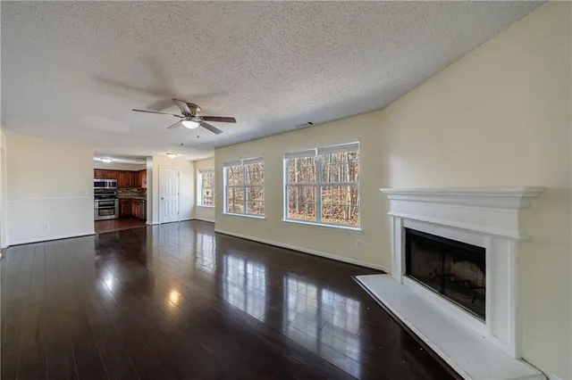 an empty room with windows and fireplace