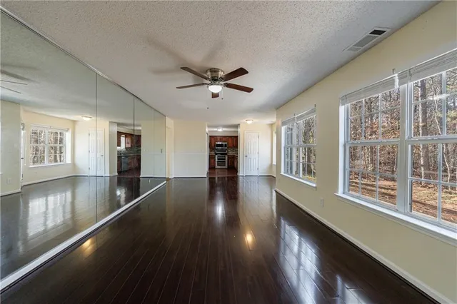 a view of a hallway with wooden floor and a window