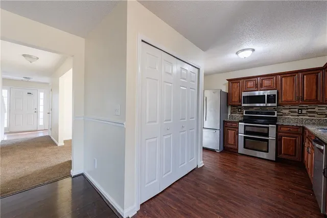 a view of kitchen with stainless steel appliances cabinets and wooden floor