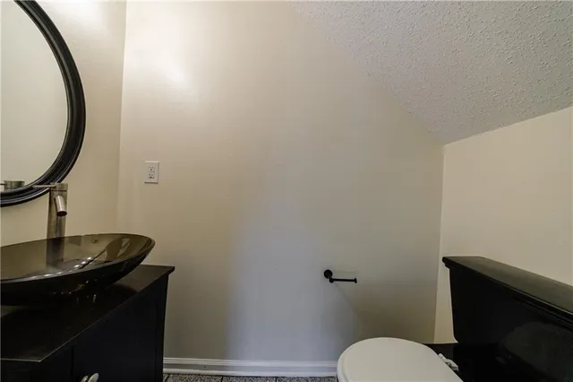 a bathroom with a toilet a sink and mirror