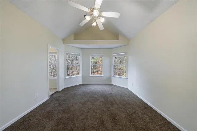 an empty room with a bathroom and a ceiling fan