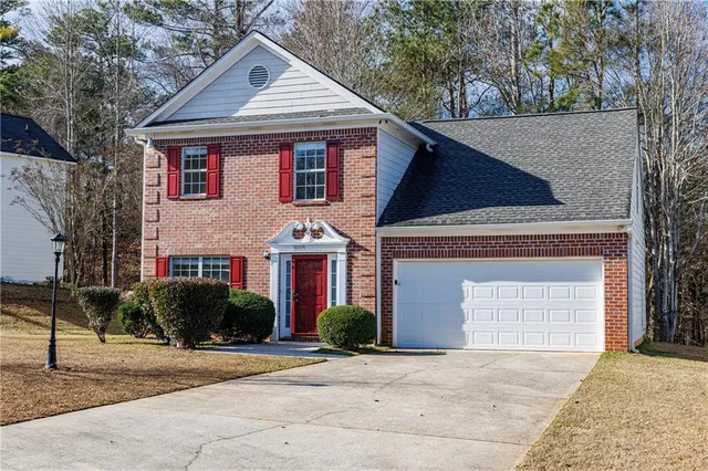 a front view of a house with plants and trees