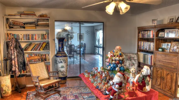 a kitchen with stainless steel appliances granite countertop a refrigerator a sink a stove and a dining table with wooden floor