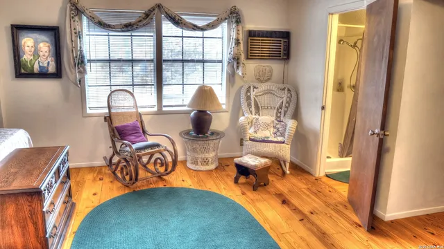a bedroom with a bed and large windows