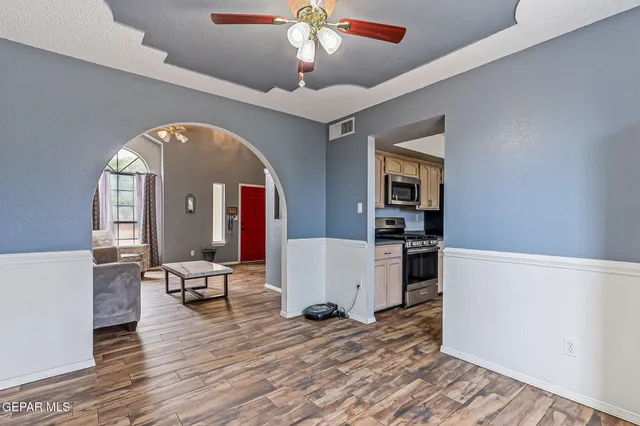 a view of a livingroom with furniture wooden floor and a ceiling fan