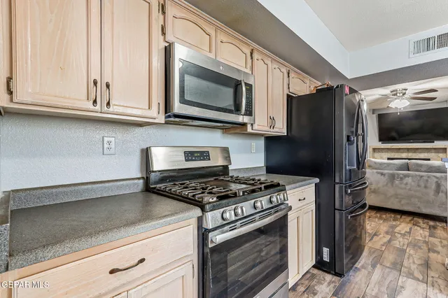 a kitchen with stainless steel appliances granite countertop a refrigerator stove and microwave