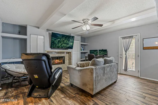 a living room with furniture a flat screen tv and a fireplace
