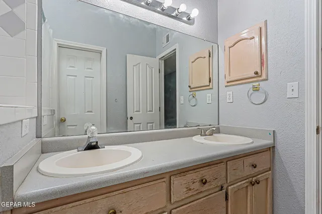 a bathroom with a double vanity sink and a mirror