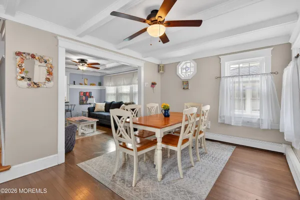 a view of a dining room with furniture and a chandelier fan