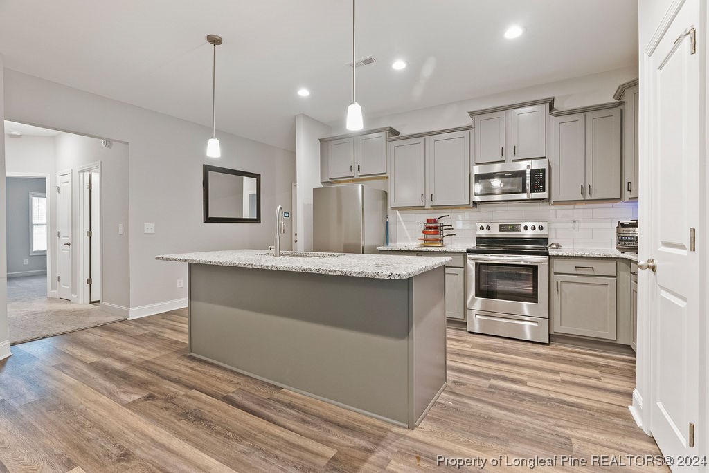 7751 Rufus Johnson Road Fayetteville, NC 28306 - Photo 8 of 21 a kitchen with kitchen island a sink stainless steel appliances and cabinets