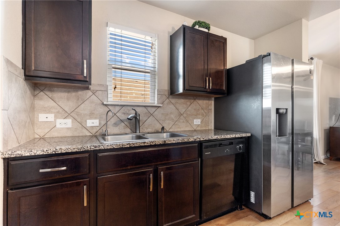 117 Liard River Road Hutto, TX 78634 - Photo 11 of 48 a kitchen with granite countertop stainless steel appliances a refrigerator and a sink