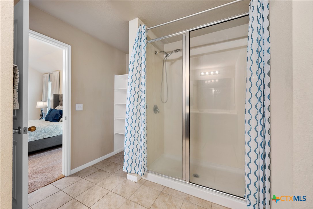 117 Liard River Road Hutto, TX 78634 - Photo 27 of 48 a bathroom with a glass shower door