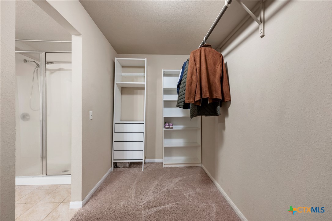 117 Liard River Road Hutto, TX 78634 - Photo 28 of 48 a view of walk in closet with clothes and shoes