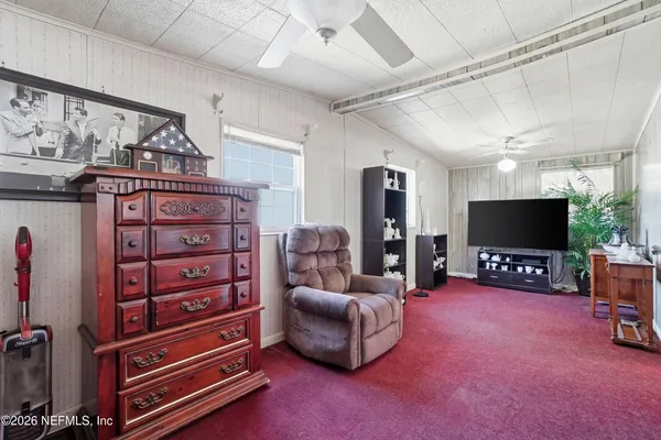 a livingroom with furniture a flat screen tv and a window